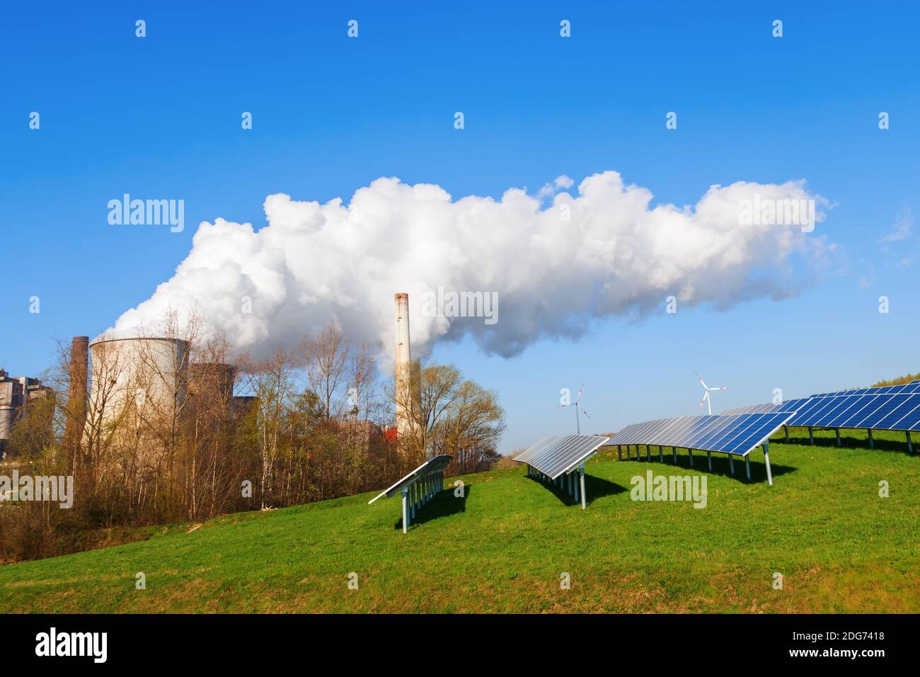 Sonnenkollektoren und fossile Kraftwerke nebeneinander Stockfoto