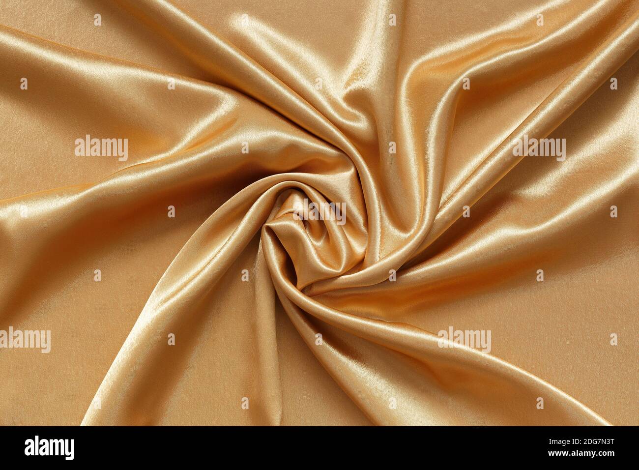 Abstrakter Hintergrund aus zerknittert glänzendem, glattem goldenem Stoff Stockfoto