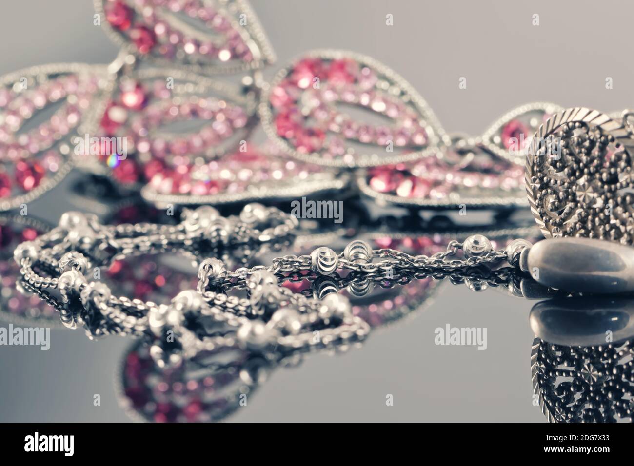 Silberschmuck auf dem Hintergrund eines Schmuckstücks mit rosa Steine Stockfoto