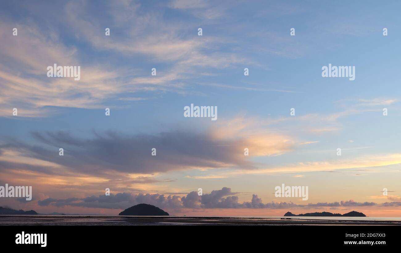 Schöner Sonnenuntergang Himmel mit Wolken und Küste am fernen Horizont. Stockfoto