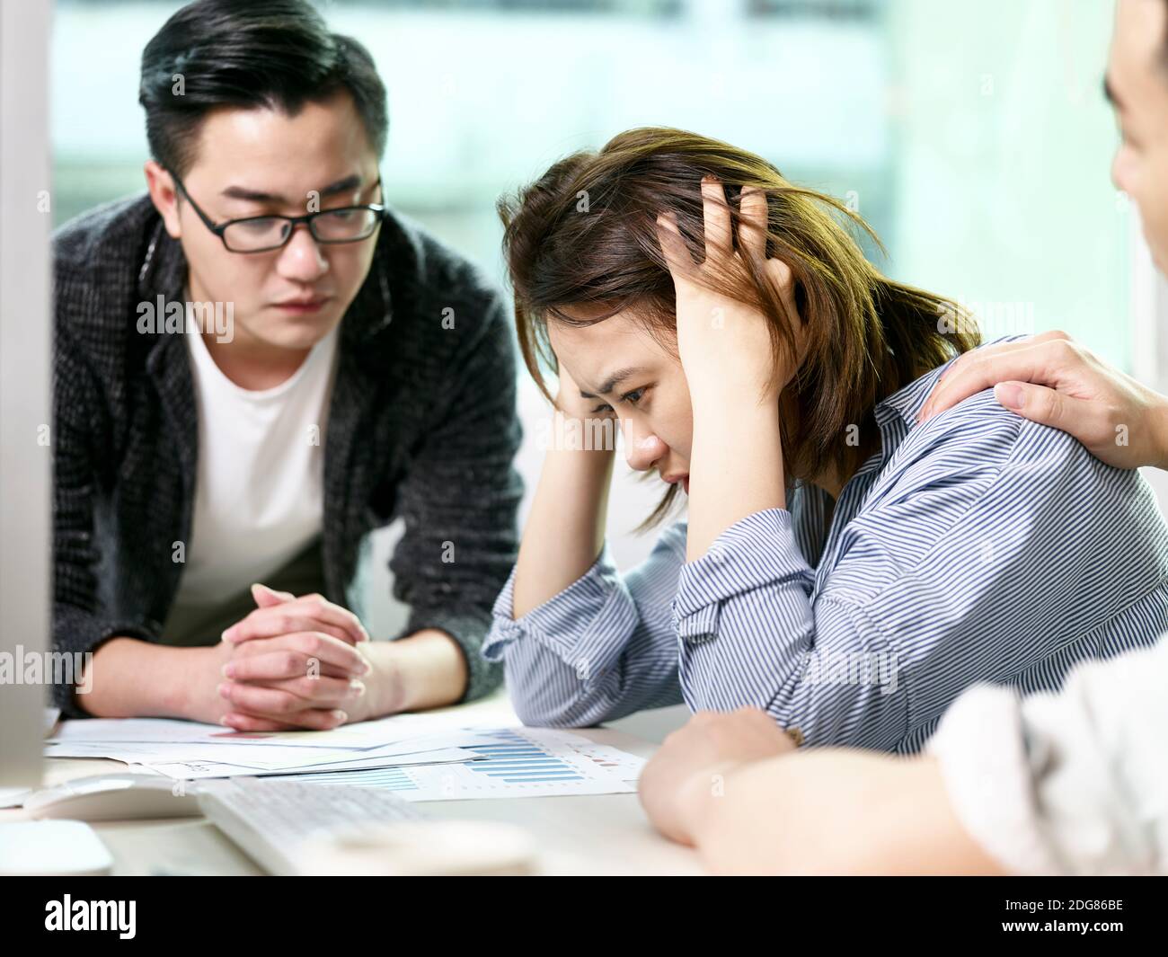 Frustrierte asiatische Geschäftsfrau bekommen Trost von Kollegen beim Gespräch Geschäft Im Büro Stockfoto