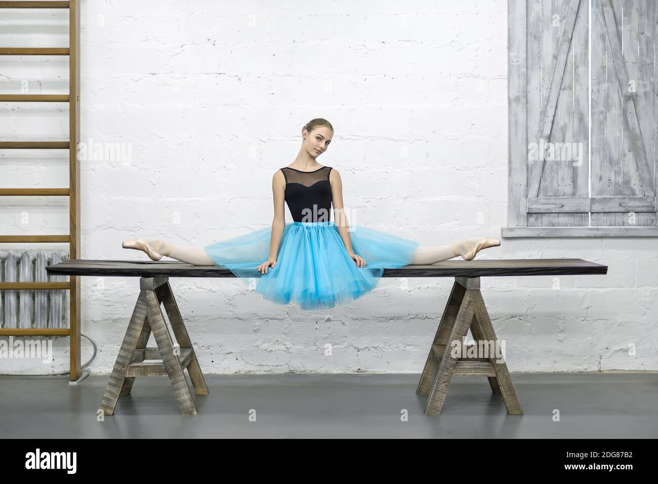 Ballerina sitzt bei Split im studio Stockfoto