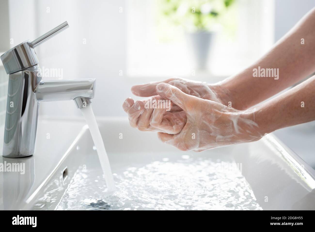Nahaufnahme Teenager-Junge waschen Hände mit Seife und Wasser Am Waschbecken Stockfoto