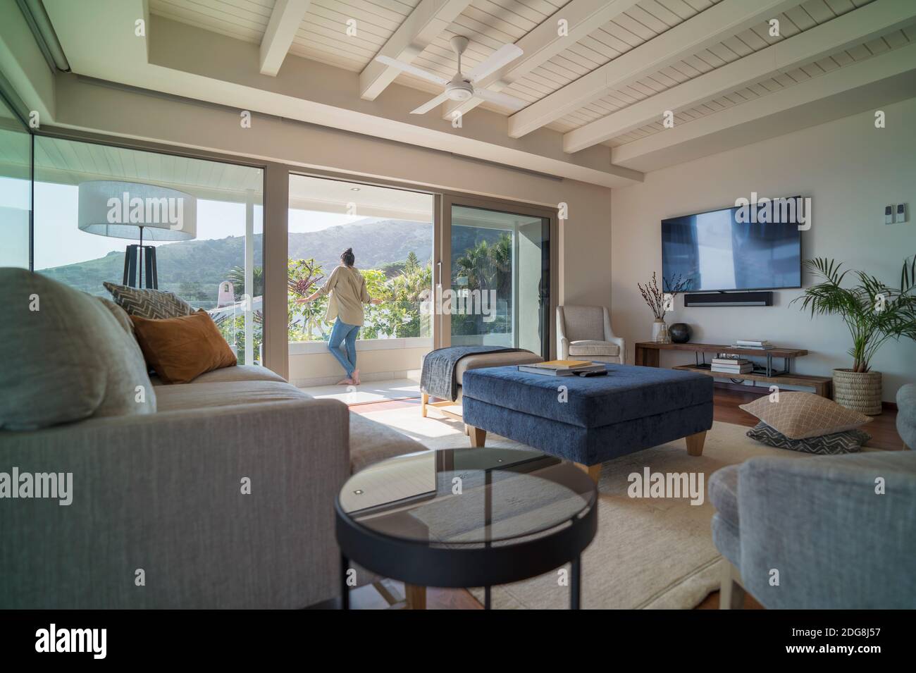 Frau genießen sonnigen Blick von Luxus-Haus Schaufenster Balkon Stockfoto