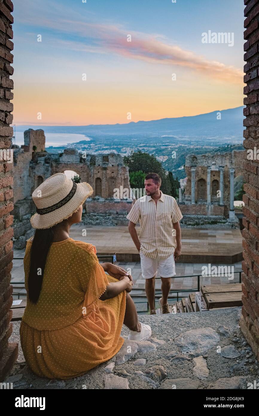 Taormina Sizilien, Paar beobachten Sonnenuntergang auf den Ruinen des antiken griechischen Theaters in Taormina, Sizilien. Paar mittleren Alters im Urlaub Sicilia Stockfoto