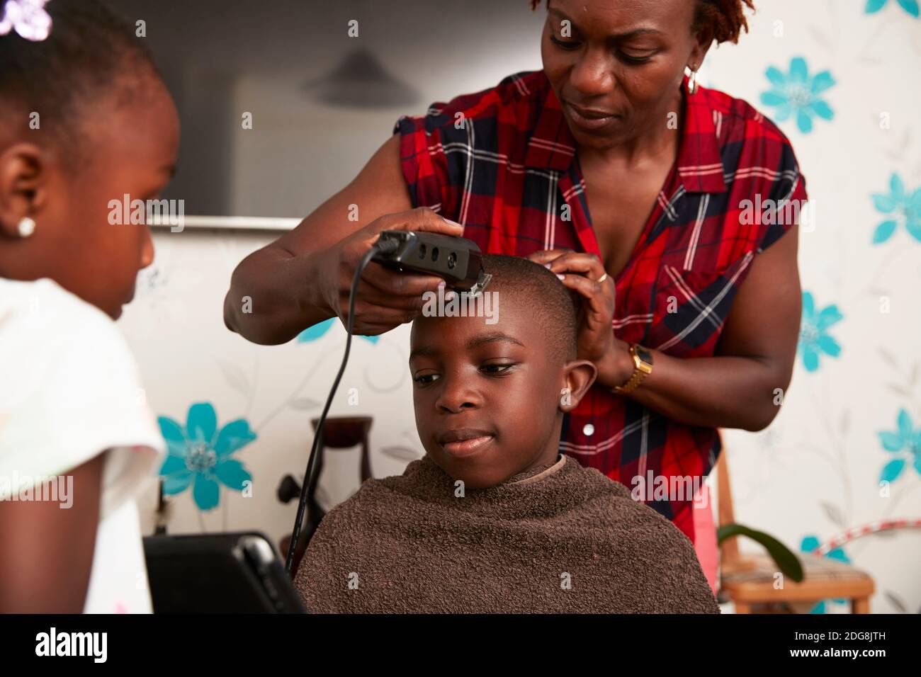 Mutter mit Schneidern schneiden Sohn Haare im Badezimmer Stockfoto