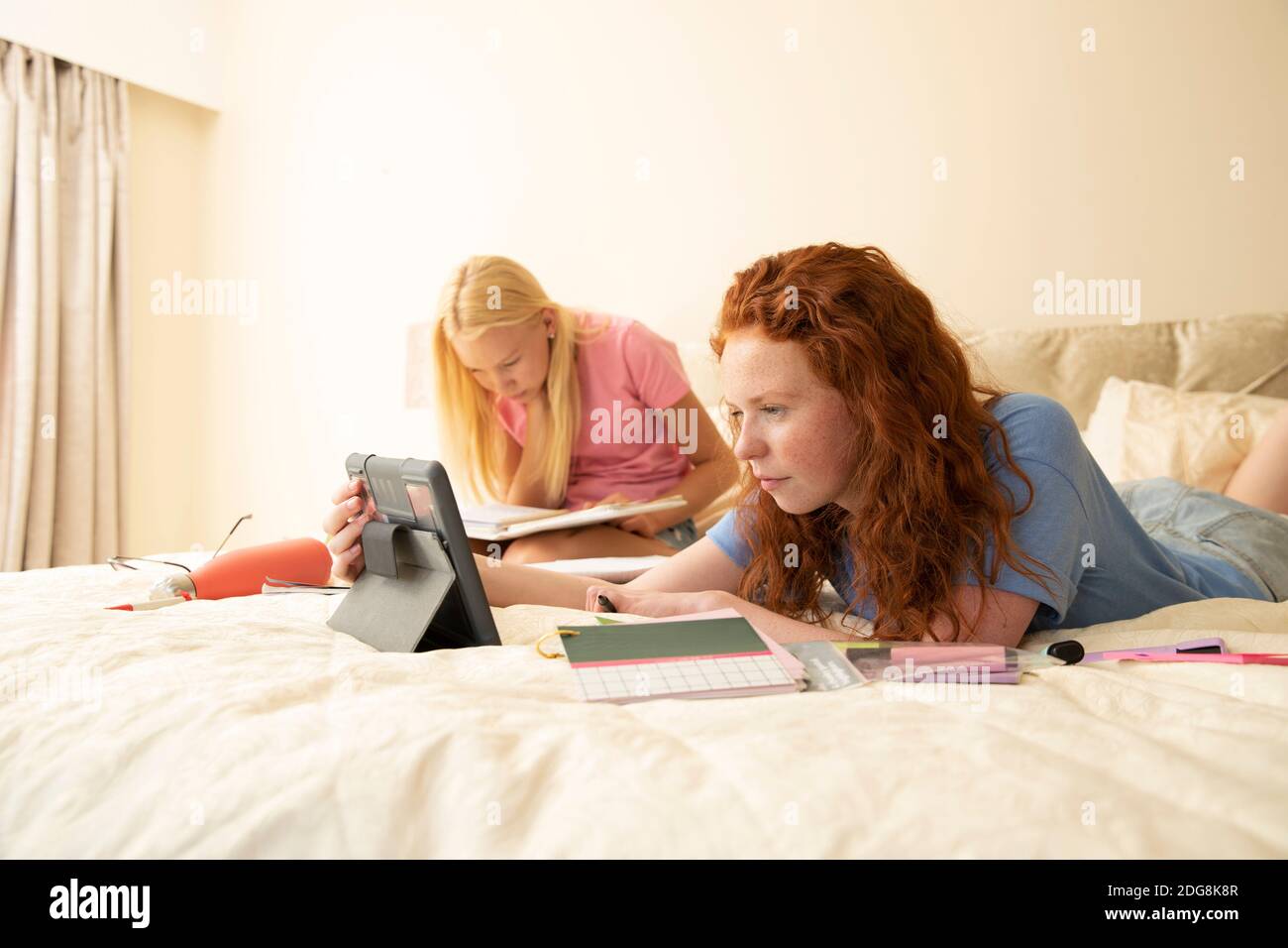 Präteen Mädchen Freunde mit digitalen Tablet Hausaufgaben auf dem Bett zu tun Stockfoto