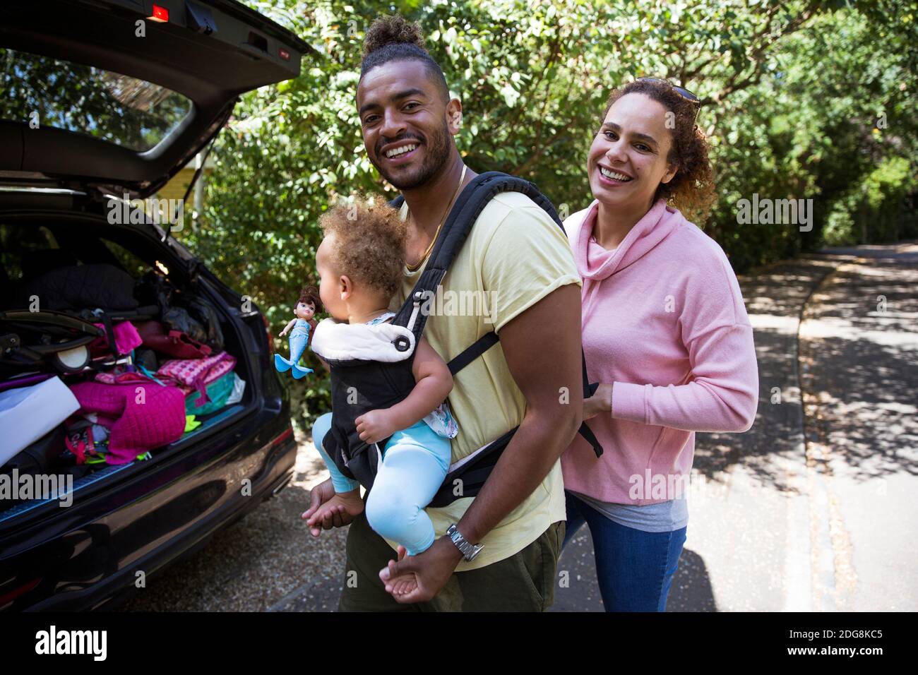 Portrait glückliches Paar mit Baby Tochter außerhalb Auto Stockfoto