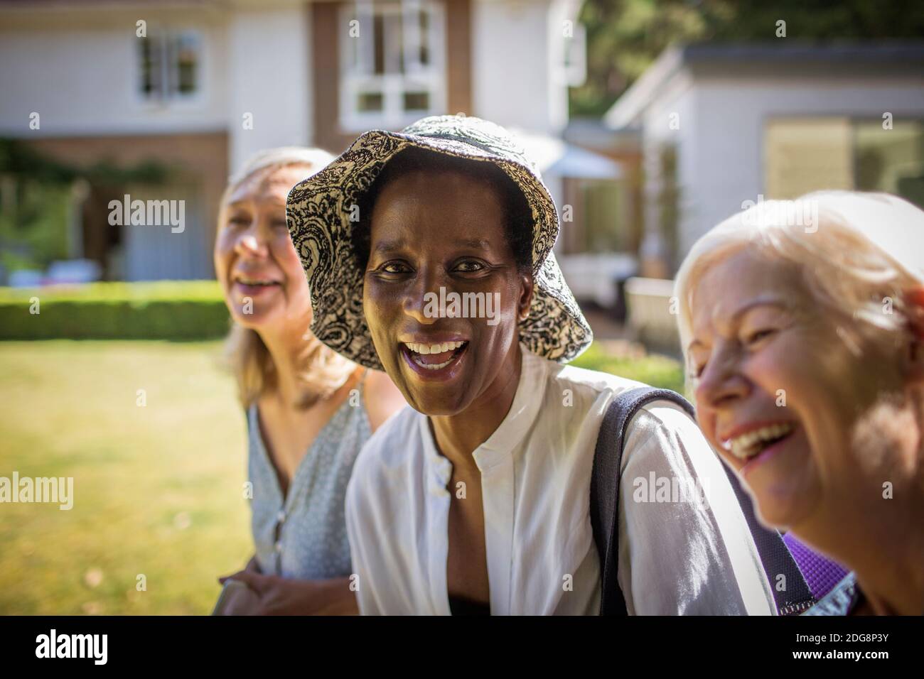 Portrait glücklich ältere Frauen Freunde in sonnigen Sommer Hinterhof Stockfoto