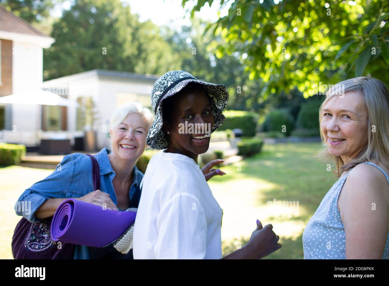 Portrait glückliche ältere Frauen mit Yogamatte im Sommergarten Stockfoto