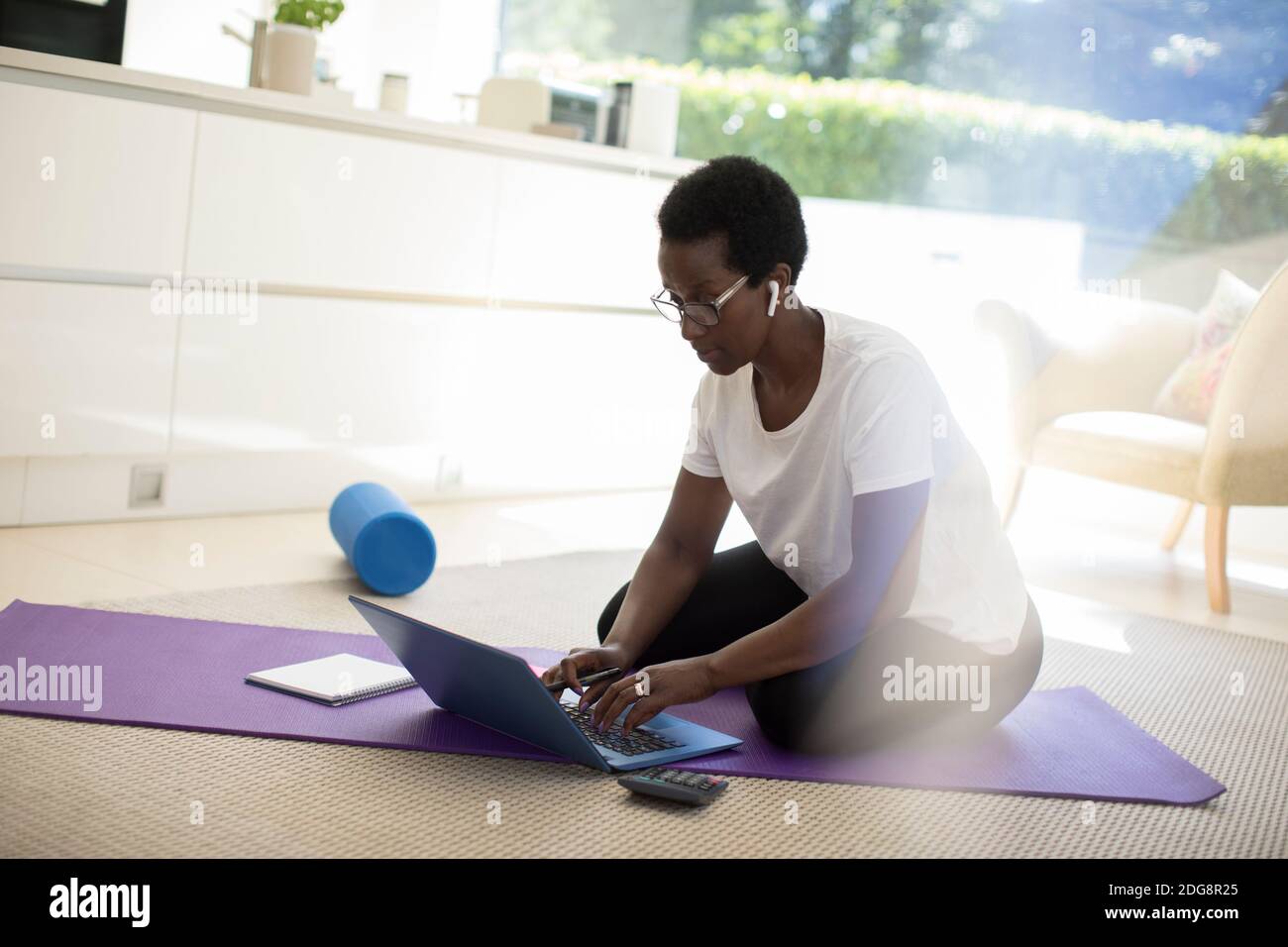 Frau, die zu Hause auf einer Yogamatte arbeitet und trainiert Stockfoto