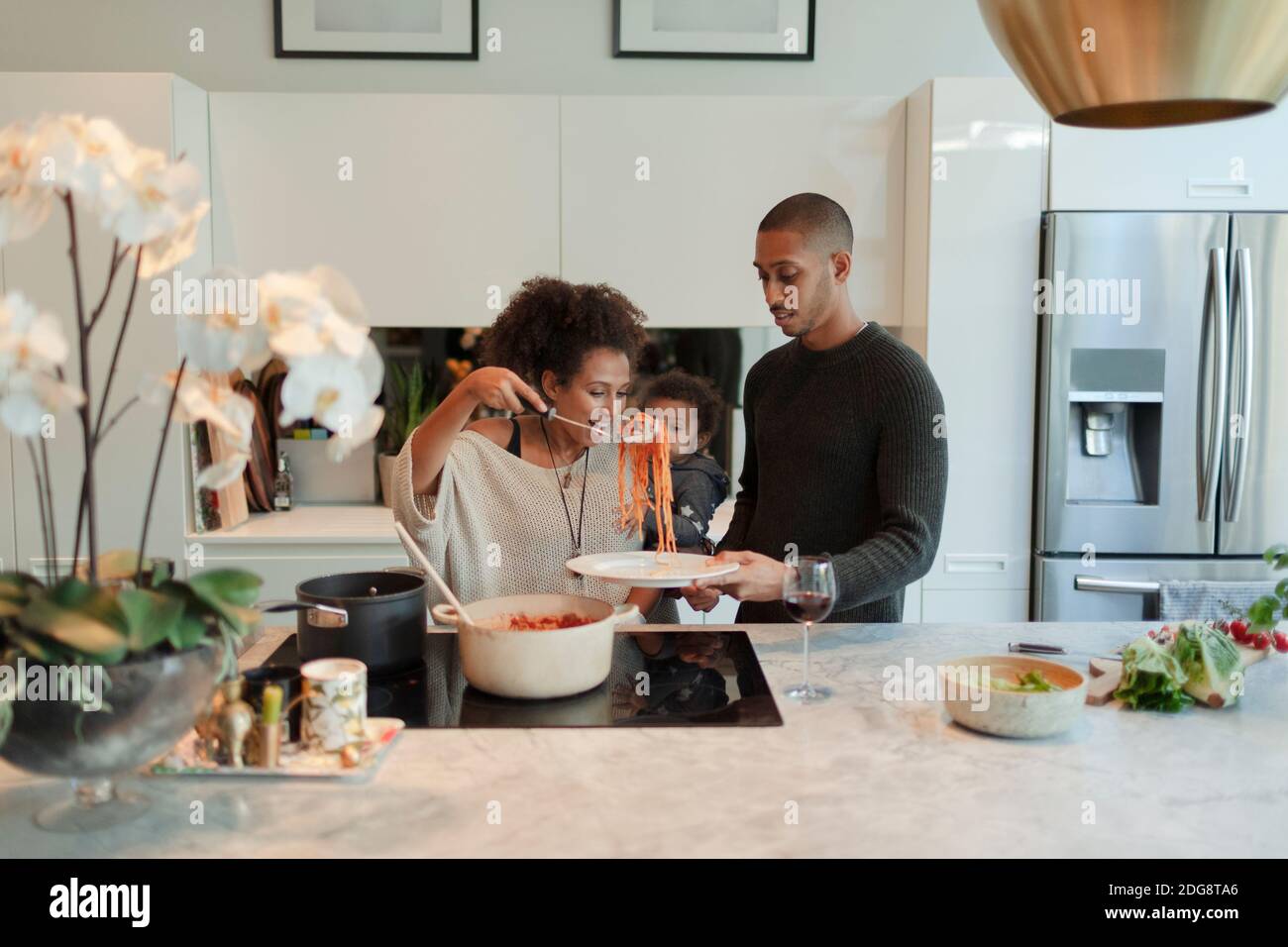 Paar mit Baby Tochter Kochen Spaghetti in der Küche Stockfoto