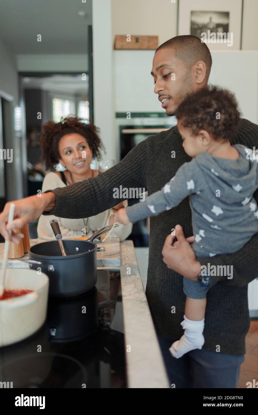 Paar mit Baby Tochter Kochen am Küchenherd Stockfoto