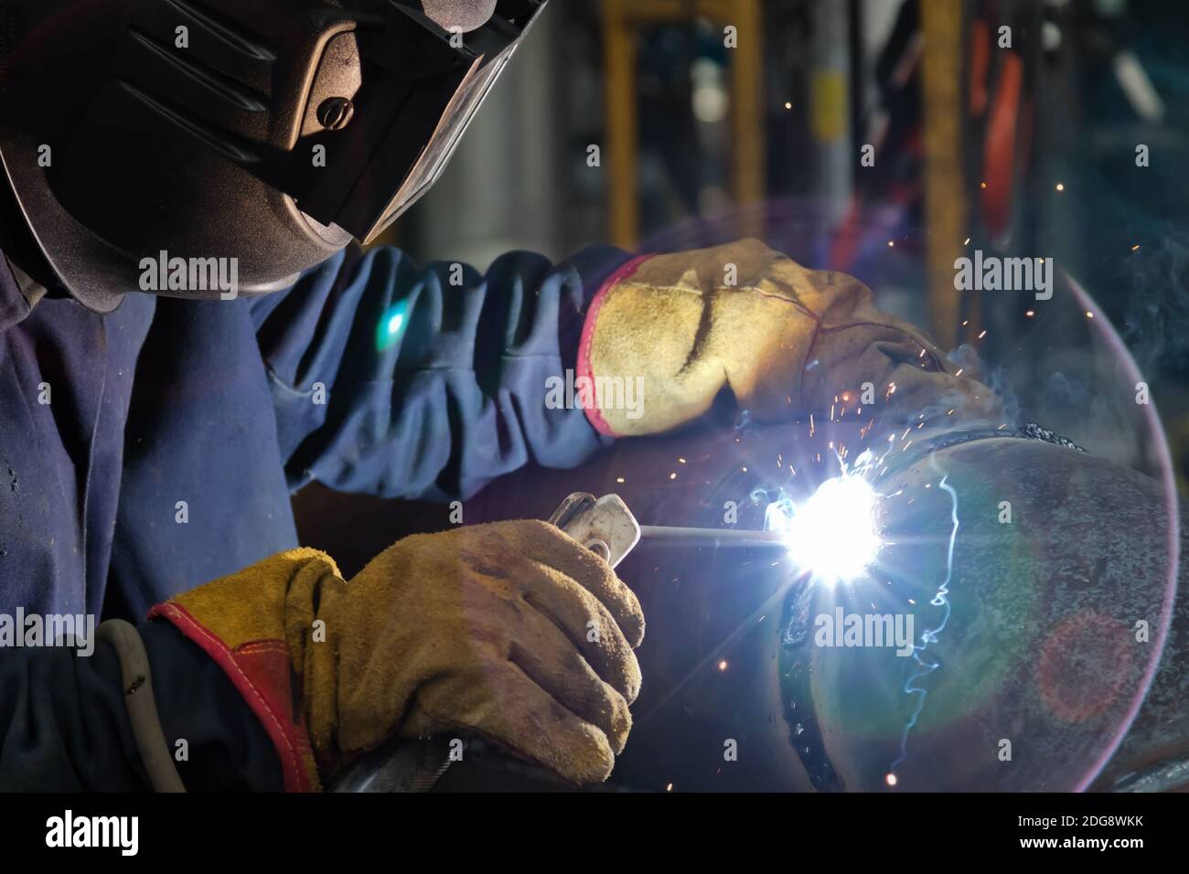 Schweißen arbeitet am Metallwärmetauscher mit manuellem Lichtbogenschweißen Stockfoto