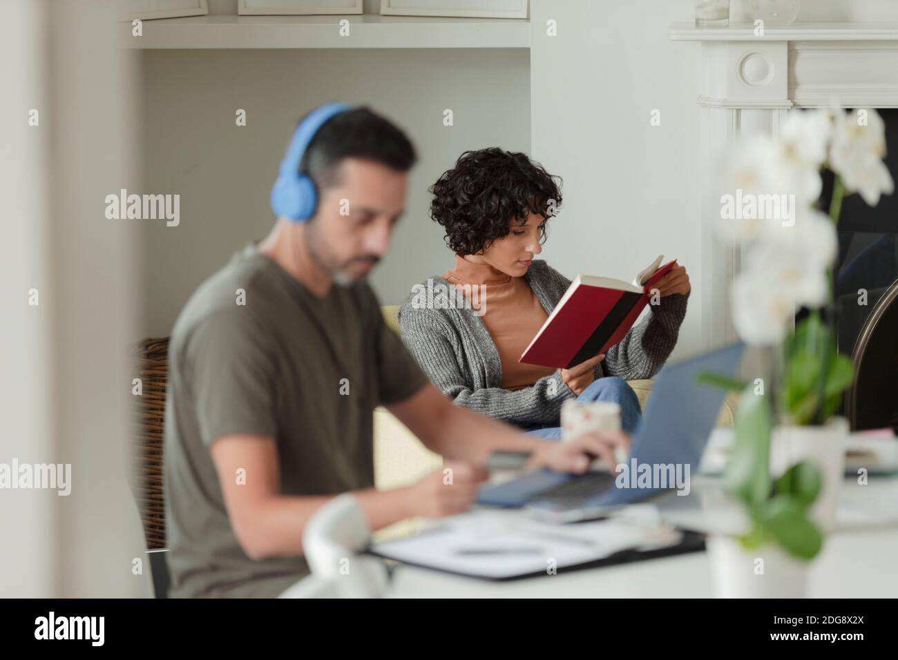 Paar lesen und arbeiten von zu Hause aus am Laptop Stockfoto
