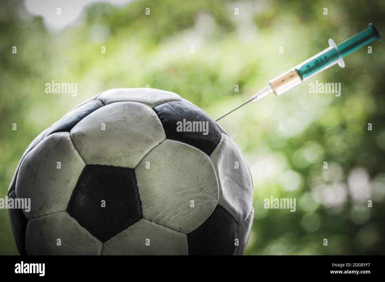 Fußball bekommt eine Injektion mit einer Spritze, Doping im Sport. Stockfoto