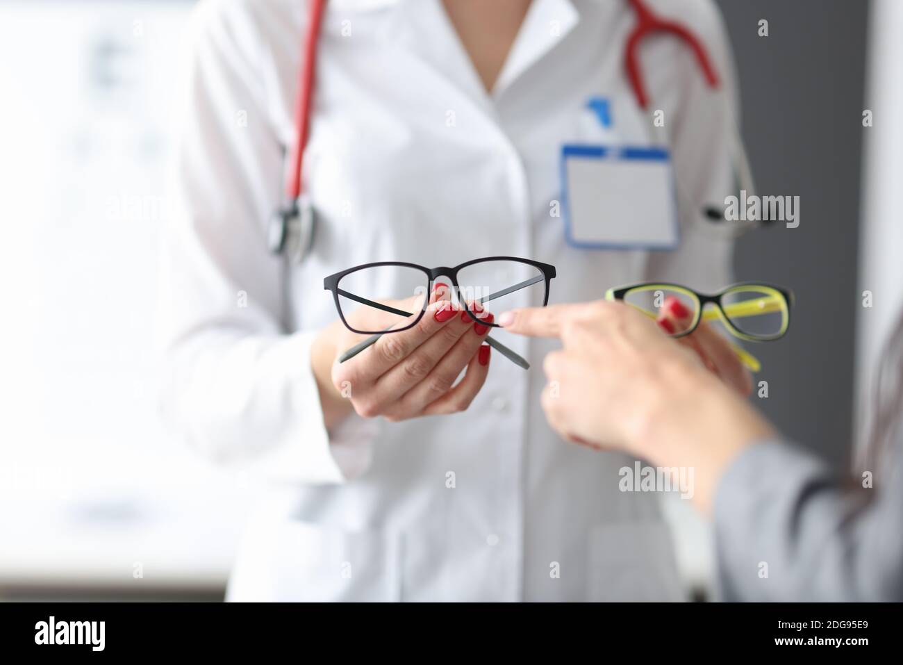 Der Augenarzt zeigt dem Patienten zwei Optikpaare. Stockfoto