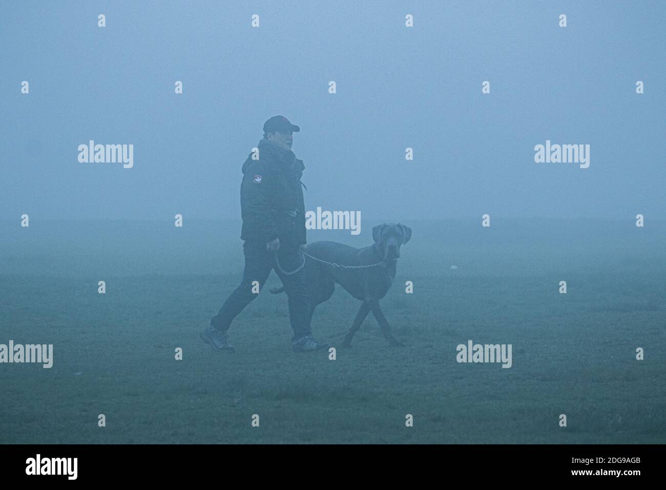WIMBLEDON LONDON 8. Dezember 2020. Ein Mann, der seinen Hund durch dichten Nebel auf Wimbledon Common läuft, während London bei eisigen Temperaturen aufwacht Credit: amer ghazzal/Alamy Live News Stockfoto