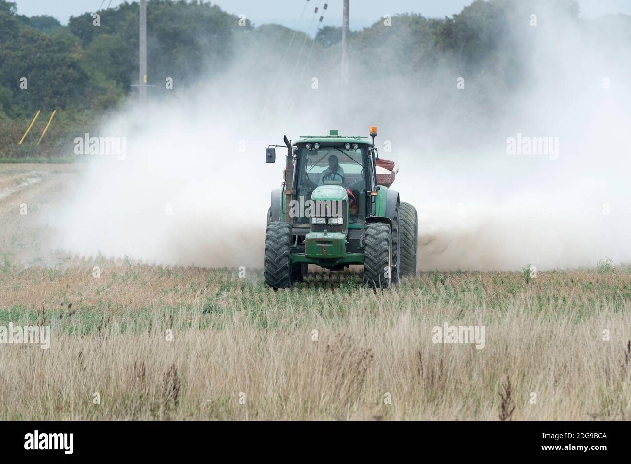 Ein John Deere Traktor verteilt Kalkdünger auf Ackerland in Hayling Island, Hampshire, Großbritannien Stockfoto