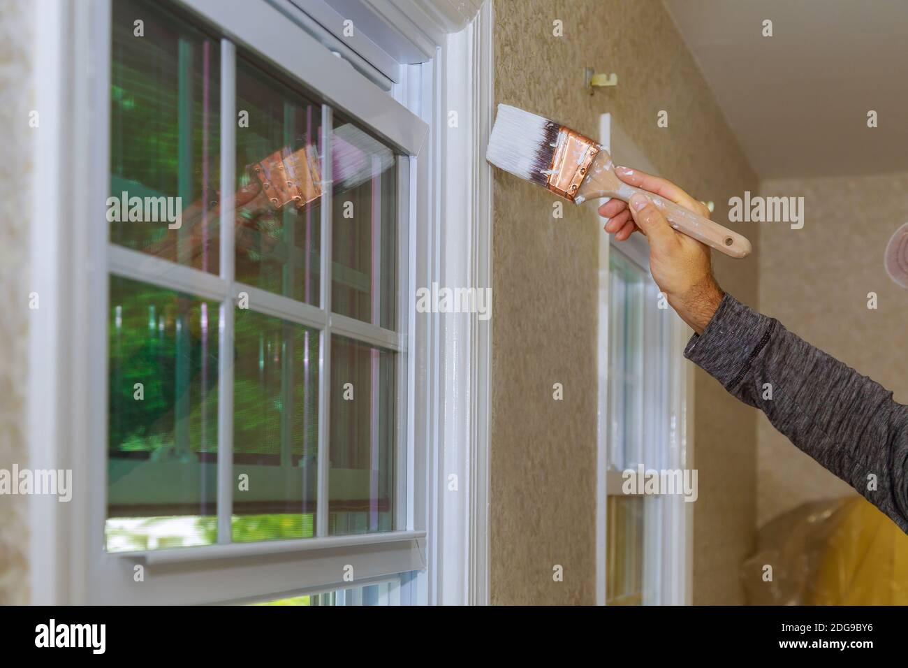 Maler malen die ein Fenster trimmen oder Formen eines Haus Stockfoto