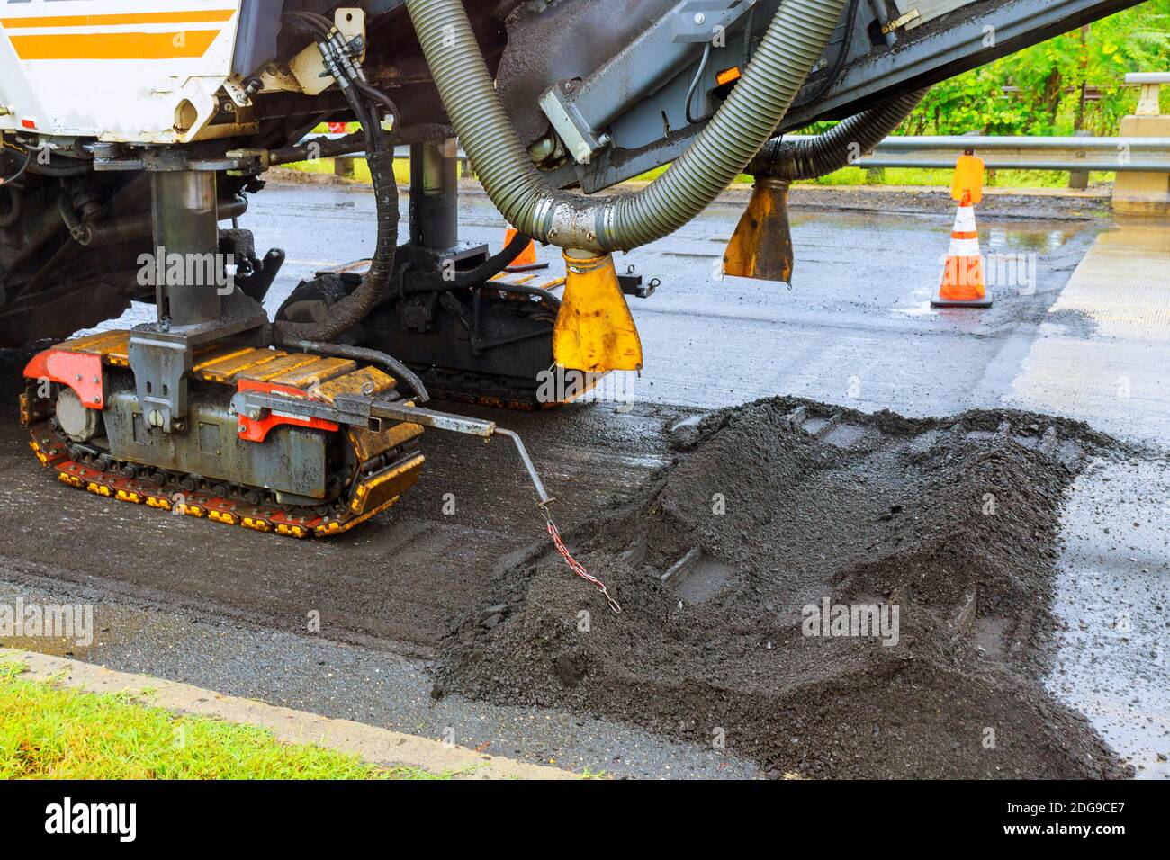 Reparatur der Stadt Asphalt auf der Straße. Eine orangefarbene Bagger gegraben ein Graben für den Austausch alter Asphalt Stockfoto