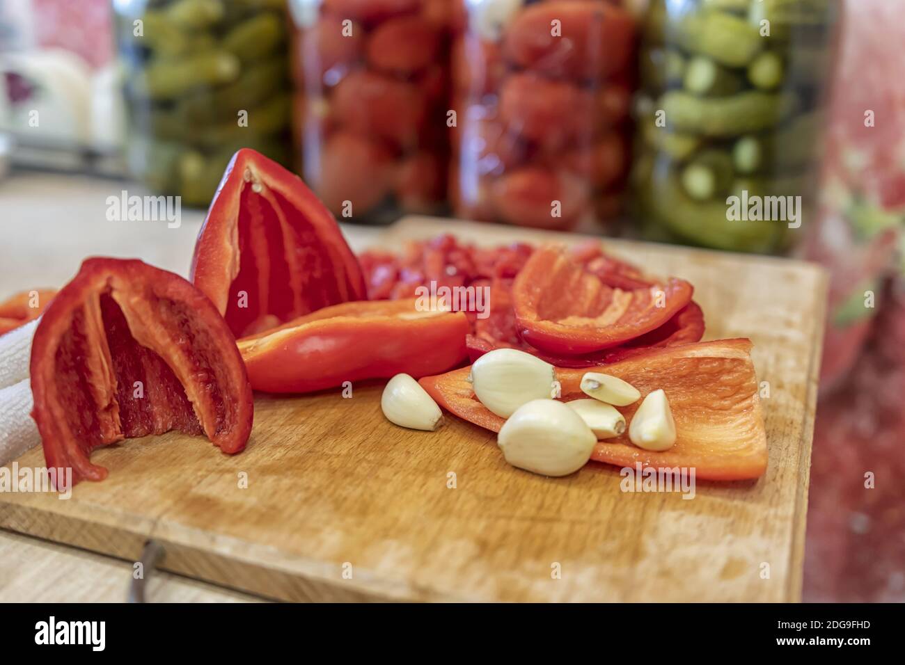 Geschälte Knoblauch und gehackte rote Paprika liegen auf einem Schneidebrdplatte Stockfoto