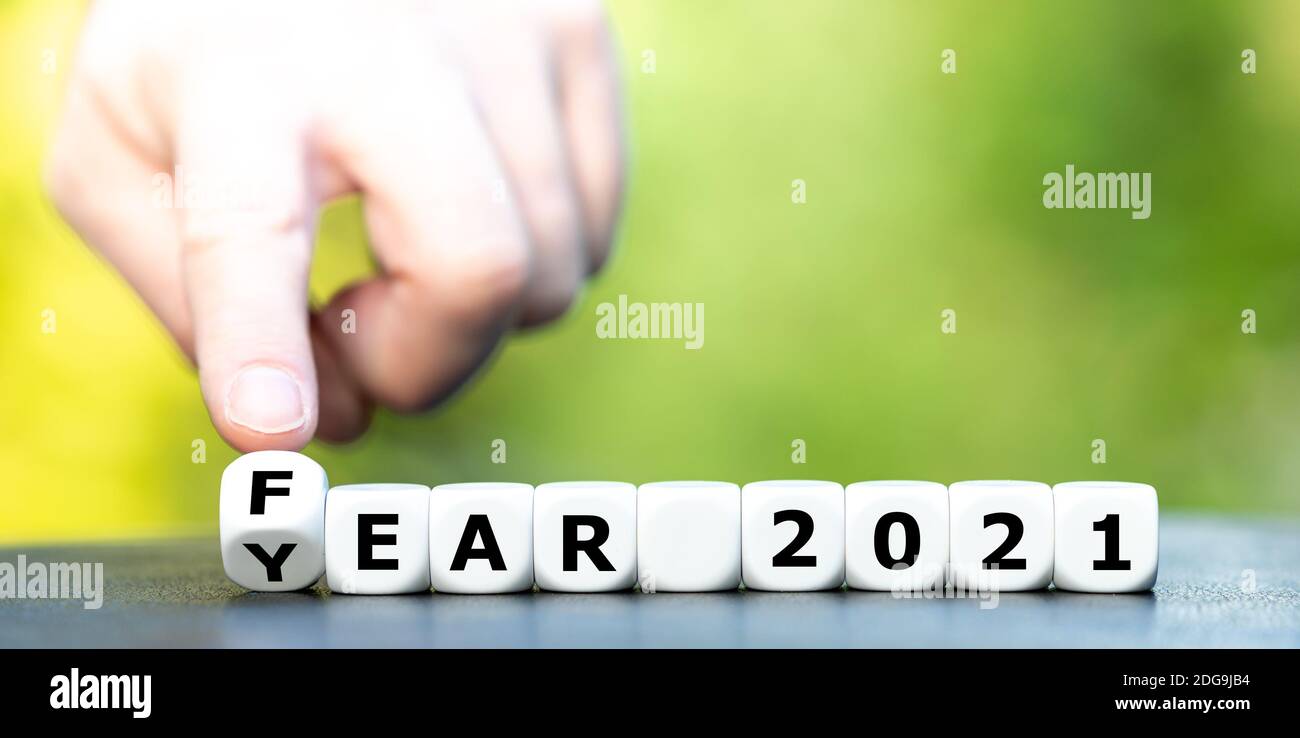 Hand dreht Würfel und ändert den Ausdruck 'Jahr 2021' in 'Angst 2021'. Stockfoto