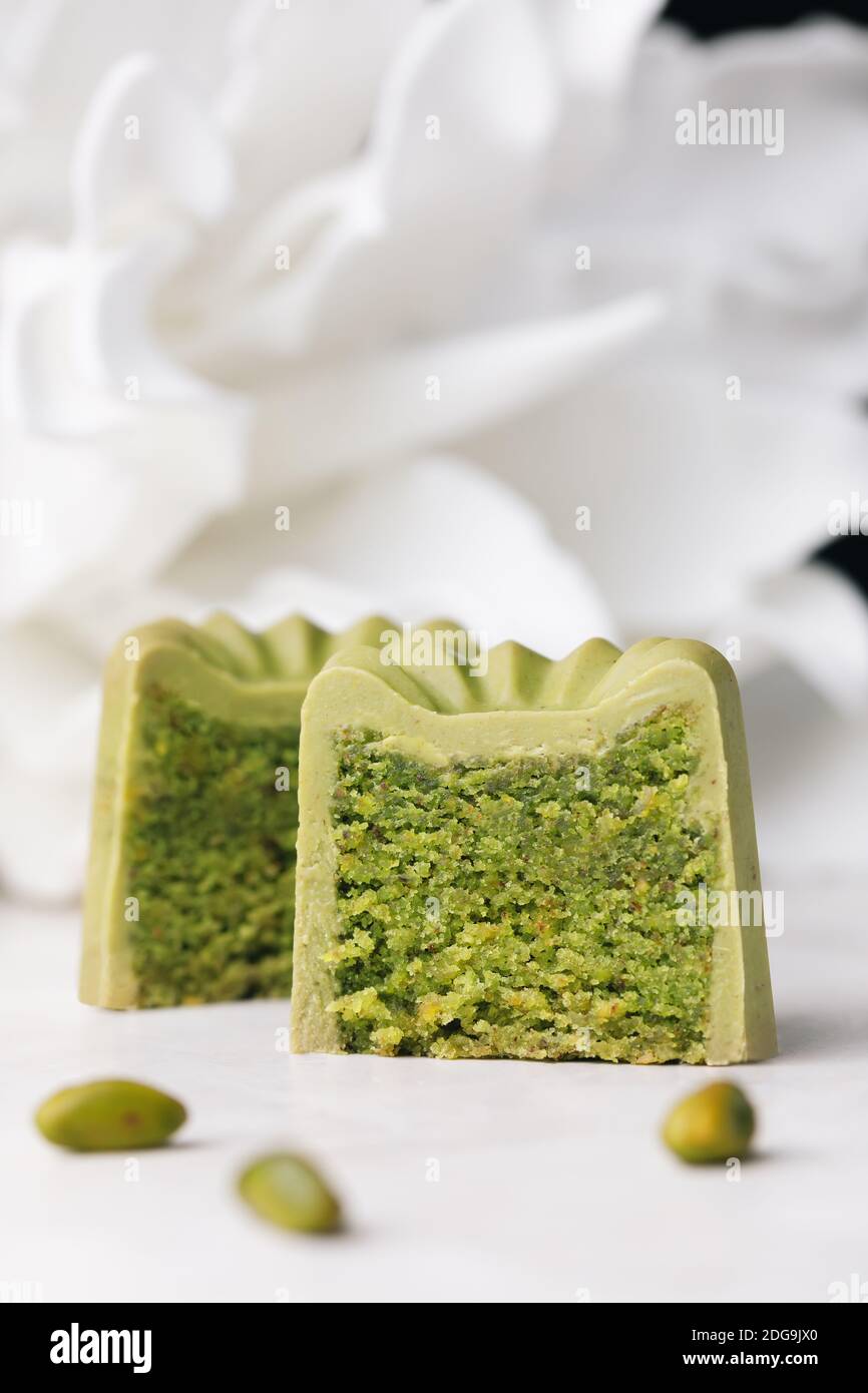 Hausgemachte Pistazien Mandeln kleinen Kuchen (Finanzier) mit Schokolade Glasur bedeckt. Modernes europäisches Kuchengebäck. Stockfoto