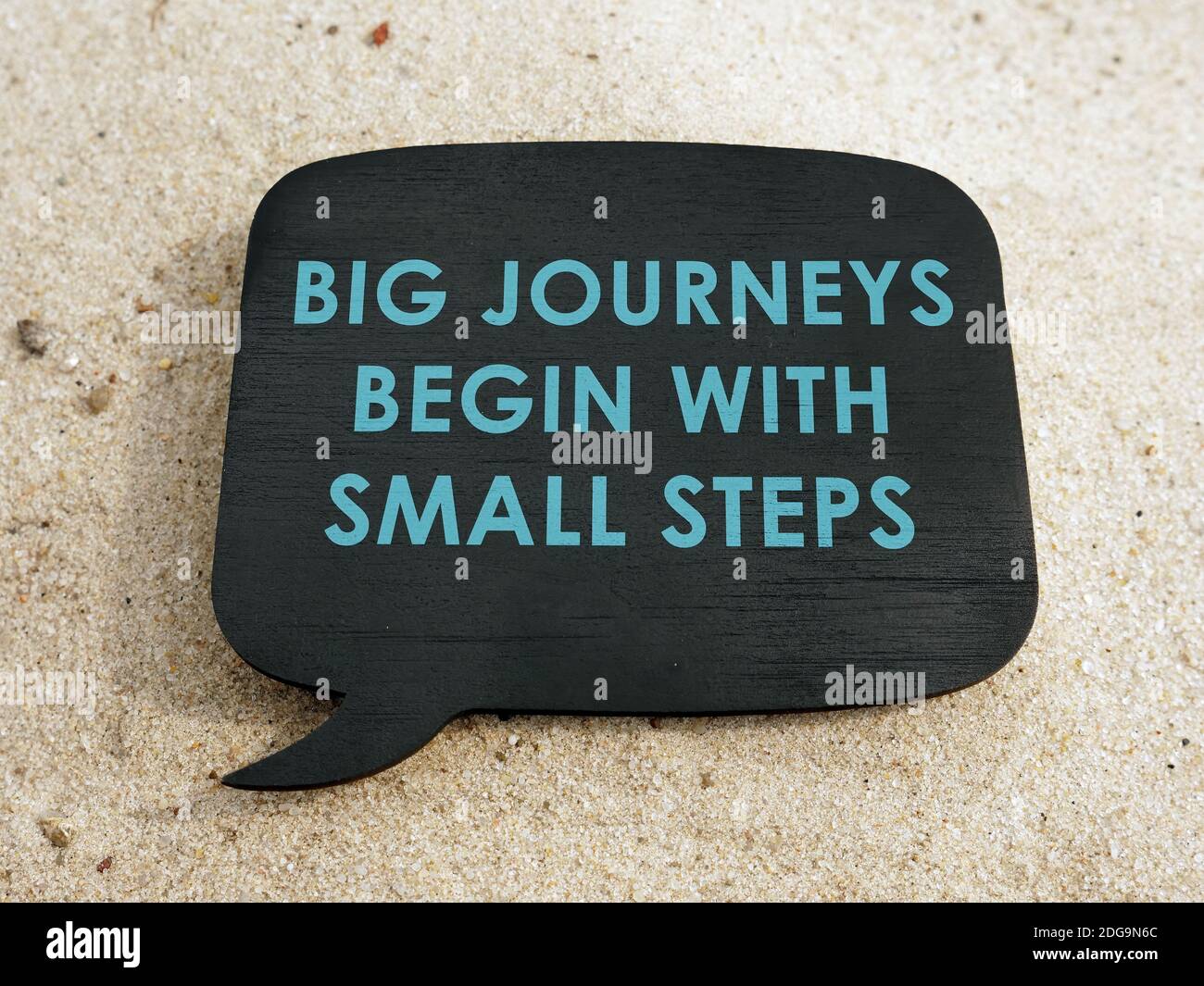 Große Reisen beginnen mit kleinen Schritten Motivation Phrase auf dem Teller. Stockfoto