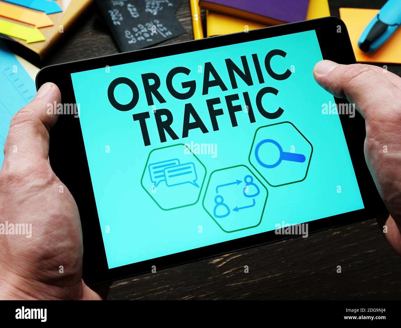 Ein Mann liest Informationen über organischen Verkehr auf einem Tablet. Stockfoto