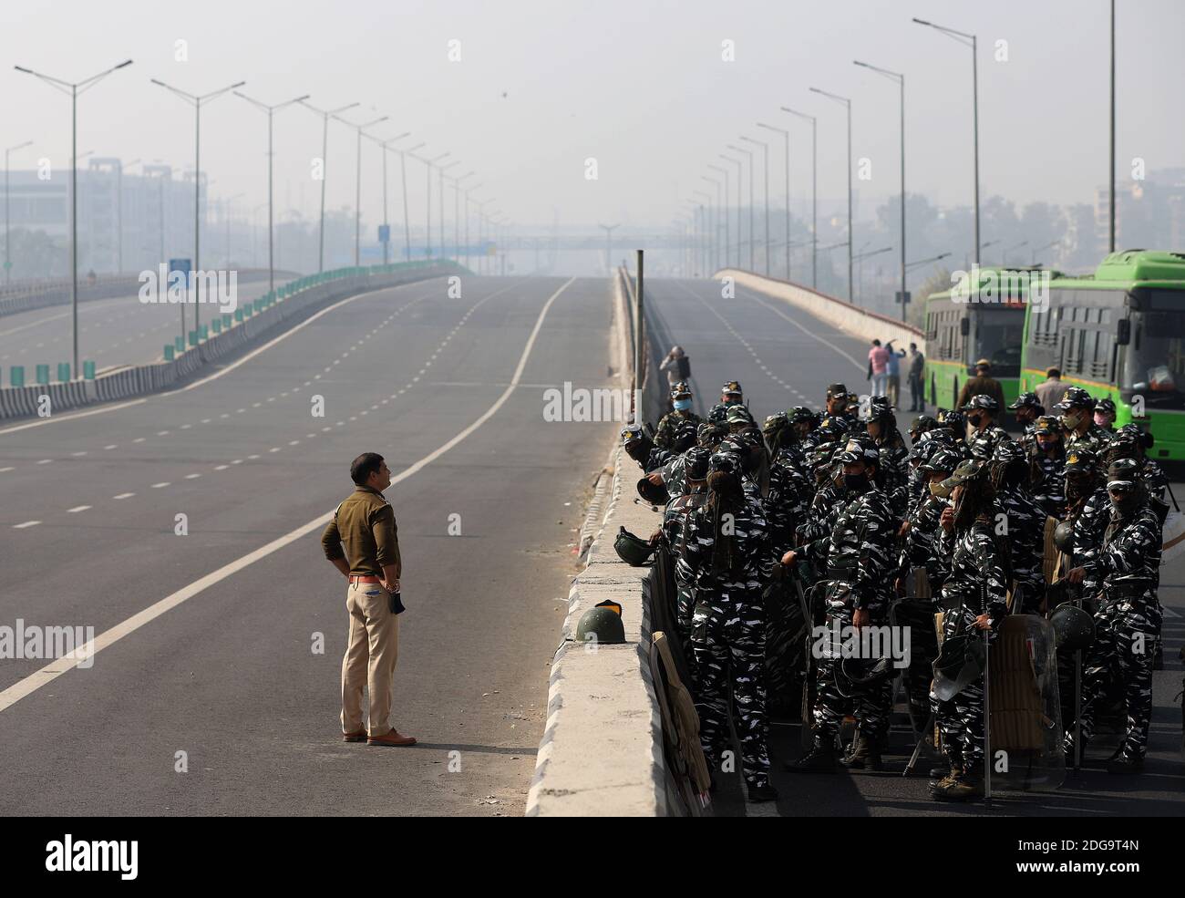 Sicherheitsbeamte auf der Autobahn ergreifen Maßnahmen während des Protests der Bauern gegen die neu verabschiedeten Agrarrechnungen. Hunderte von Bauern blockierten eine Autobahn während ihres landesweiten Protestes gegen die neu übergebenen Agrarrechnungen an der Delhi-Uttar Pradesh-Grenze in Neu-Delhi. Stockfoto