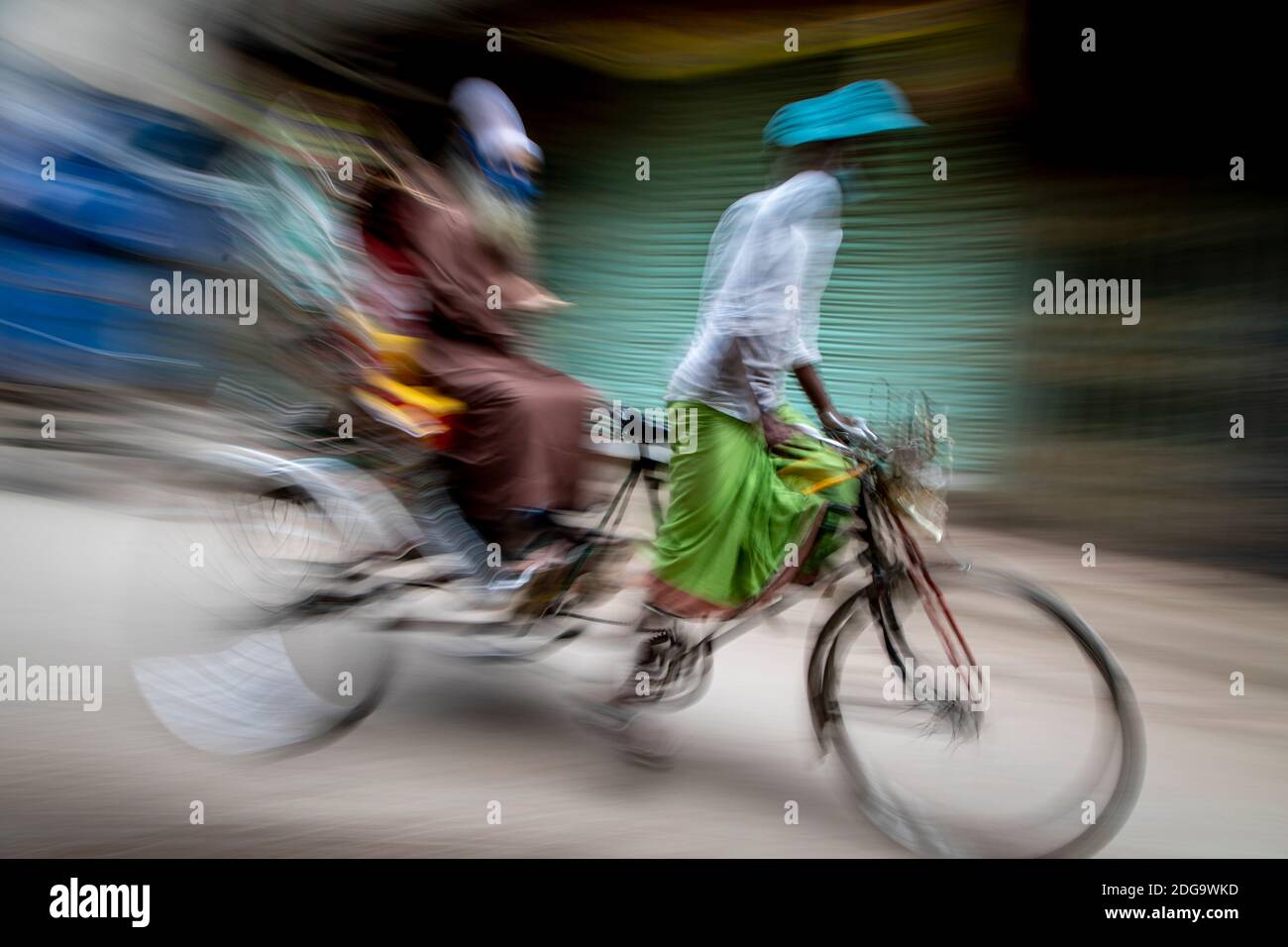 Rikscha-Abzieher auf den Straßen von Puran Dhaka - Old Dhaka in Bangladesch. Die Rikschas sind pedalbetriebene Dreiräder, wurden aber früher von Hand gezogen, daher 'Rikschas-Abzieher'. Heutzutage werden viele der Rikschas sogar auf Elektromotor umgerüstet. Stockfoto