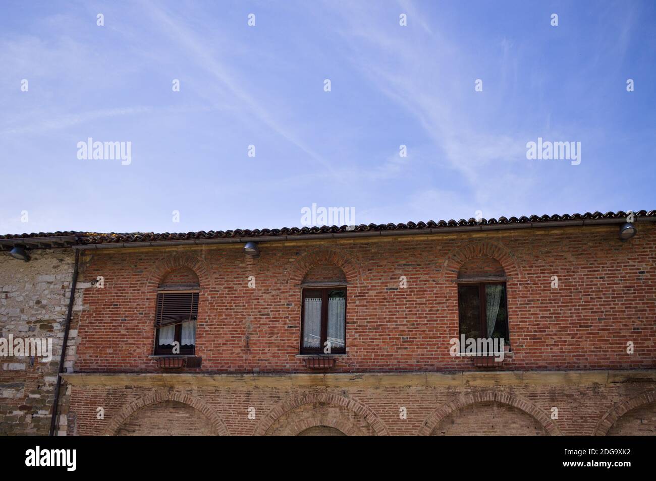 Ein altes Backsteinhaus mit Bögen und Fenstern in einem italienischen Dorf (Gubbio, Umbrien, Italien) Stockfoto