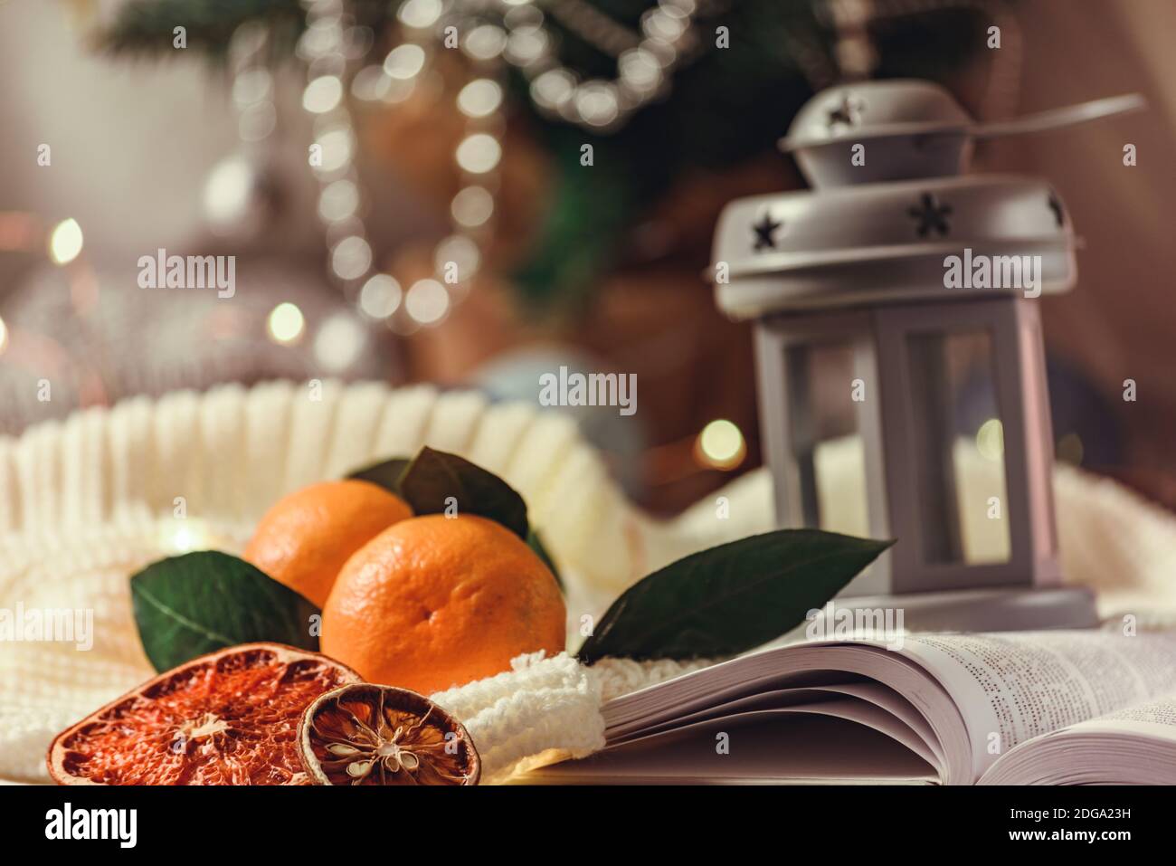 Winter und Interieur des neuen Jahres Ansicht mit einer Lampe, Buch, Girlande von Bränden und Tangerine Stockfoto