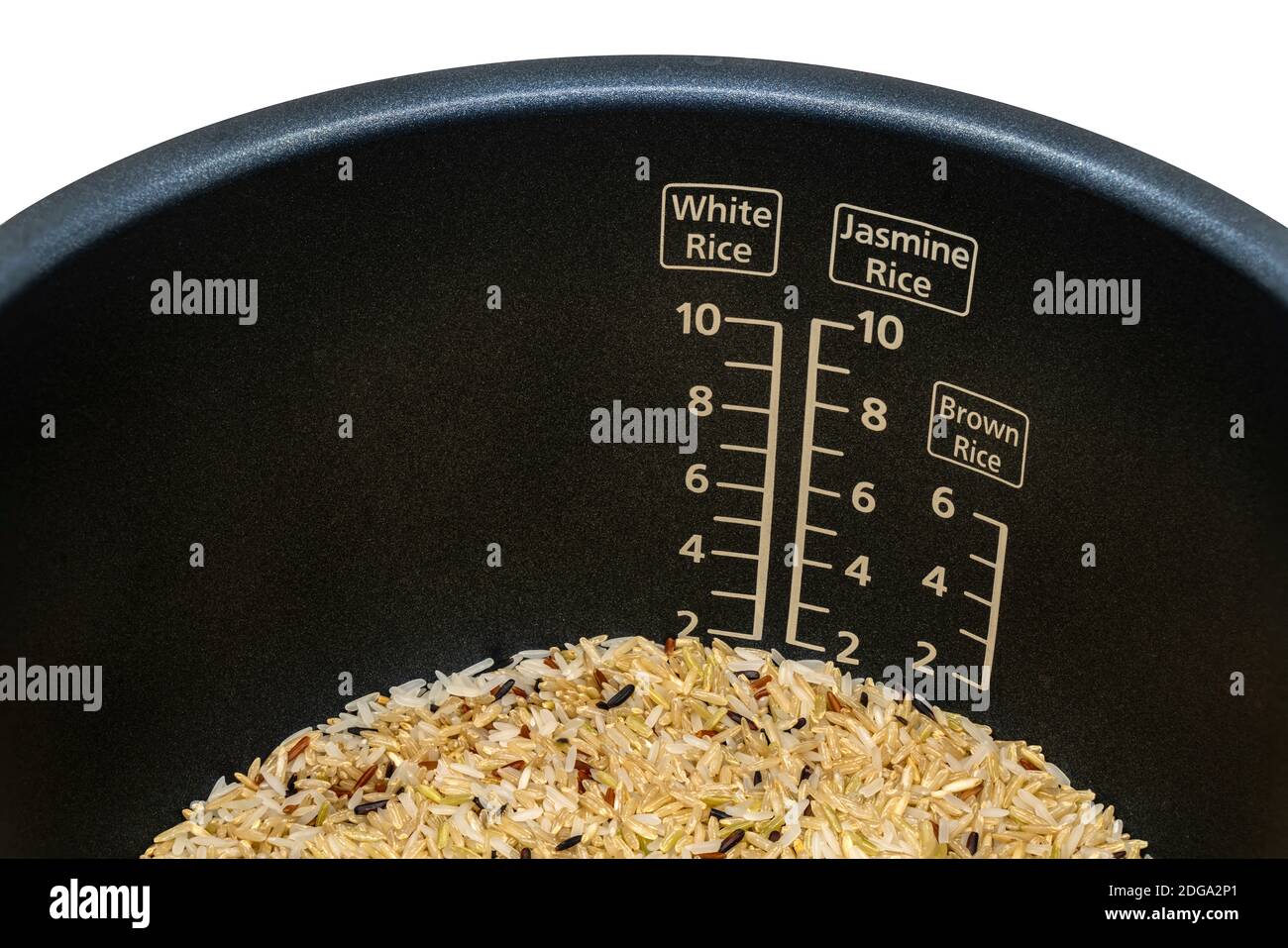 Nahaufnahme Messung skalierten inneren Topf des elektrischen Reiskocher mit braunem Reis vor dem Kochen. Messung skaliert für verschiedene Reissorten, weiß, Jasmin Stockfoto