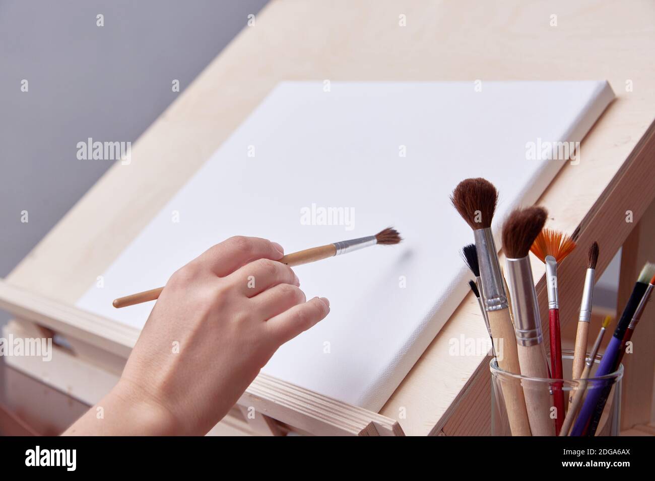 Kunstschule, die Hand des Künstlers in der Nähe des Gemäldes. Pinsel Nahaufnahme. Stockfoto