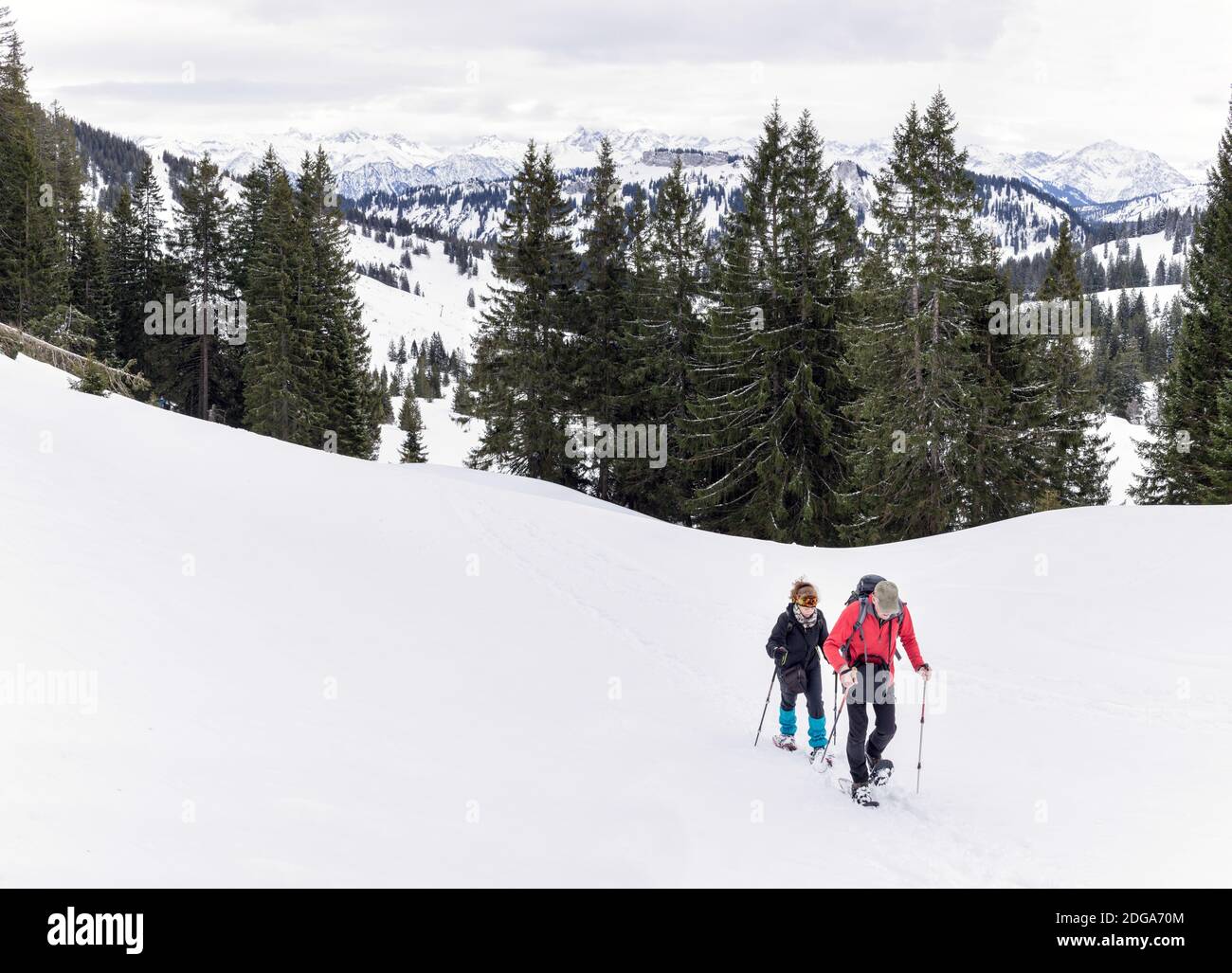 Seniorenpaar ist Schneeschuhwandern in alpinen Schnee Winter Berge. Allgau, Bayern, Deutschland. Stockfoto