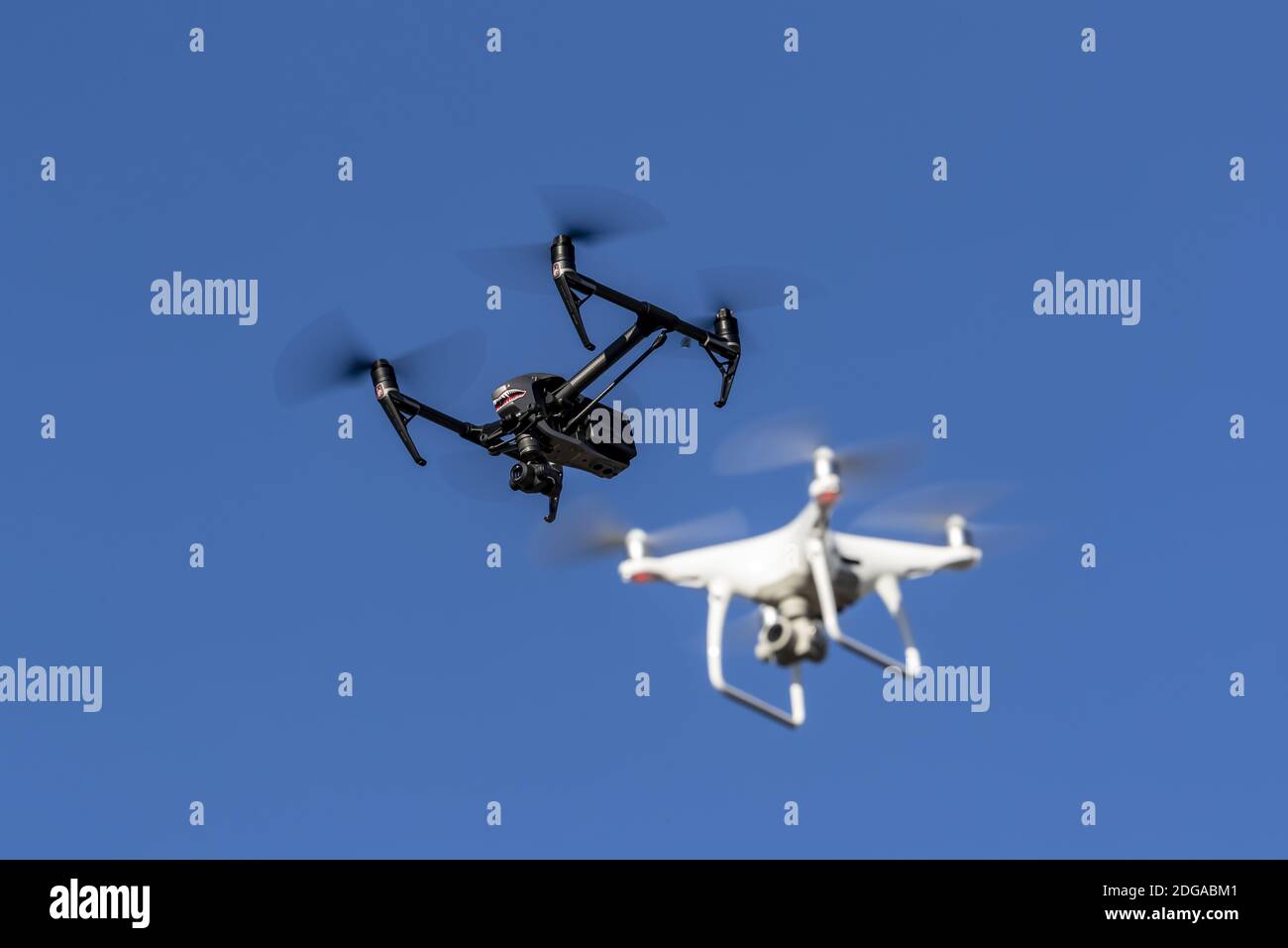 Eine Gruppe von Drohnen fliegt zusammen durch die Luft gegen Ein blauer Himmel Stockfoto