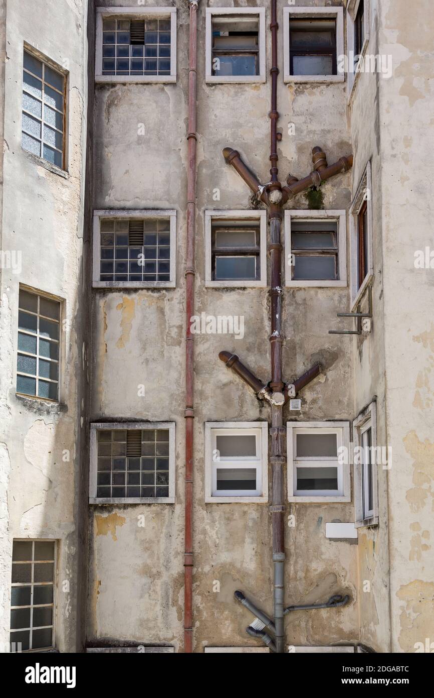 Exponierte externe Entwässerungsrohre des alten Mehrfamilienhauses in Lissabon, Portugal Stockfoto