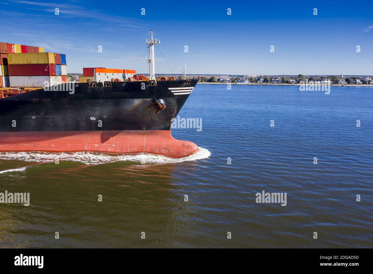 Ein Frachtschiff dampft in Richtung des offenen Ozeans aus Ein Hafen Stockfoto