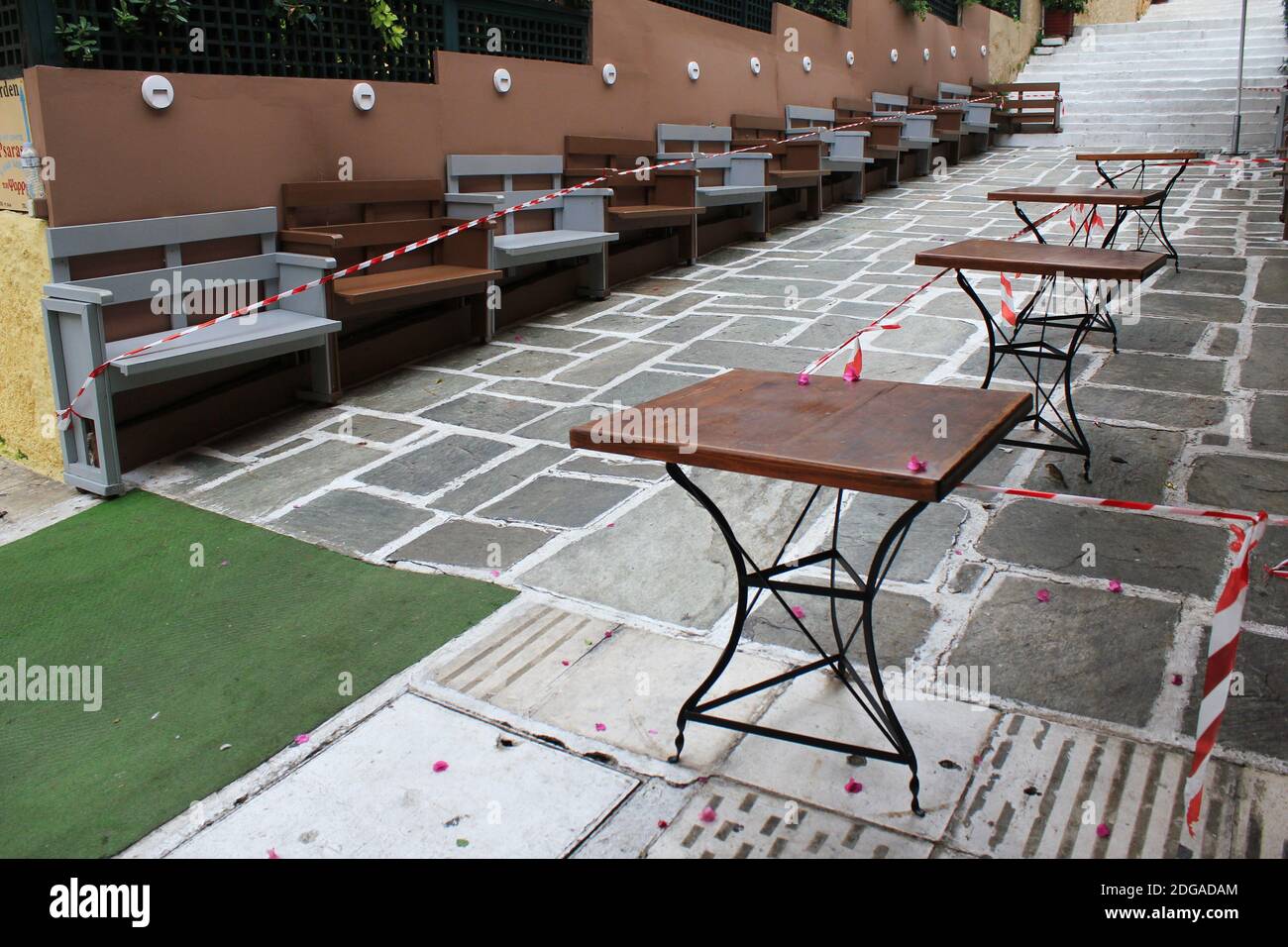 Stühle, Tische und andere Möbel vor dem geschlossenen Cafe-Restaurant auf dem Akropolis-Hügel in Athen, Griechenland, 6. November 2020 gestapelt. Stockfoto