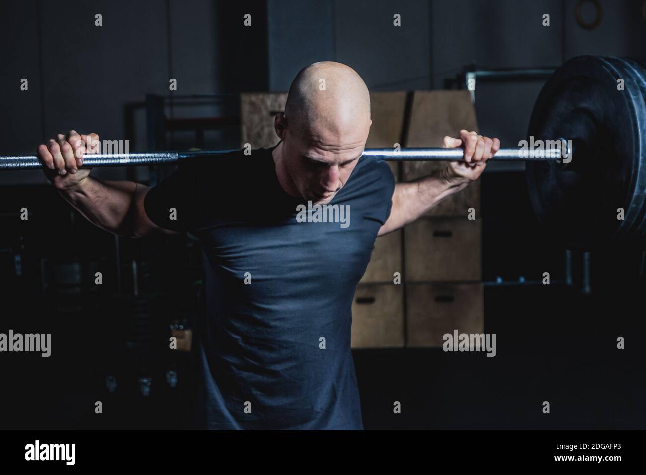 Athletic Muscular Man Halten Langhantel Auf Den Schultern In Der Turnhalle. Dramatische Farbkorrektur. Stockfoto