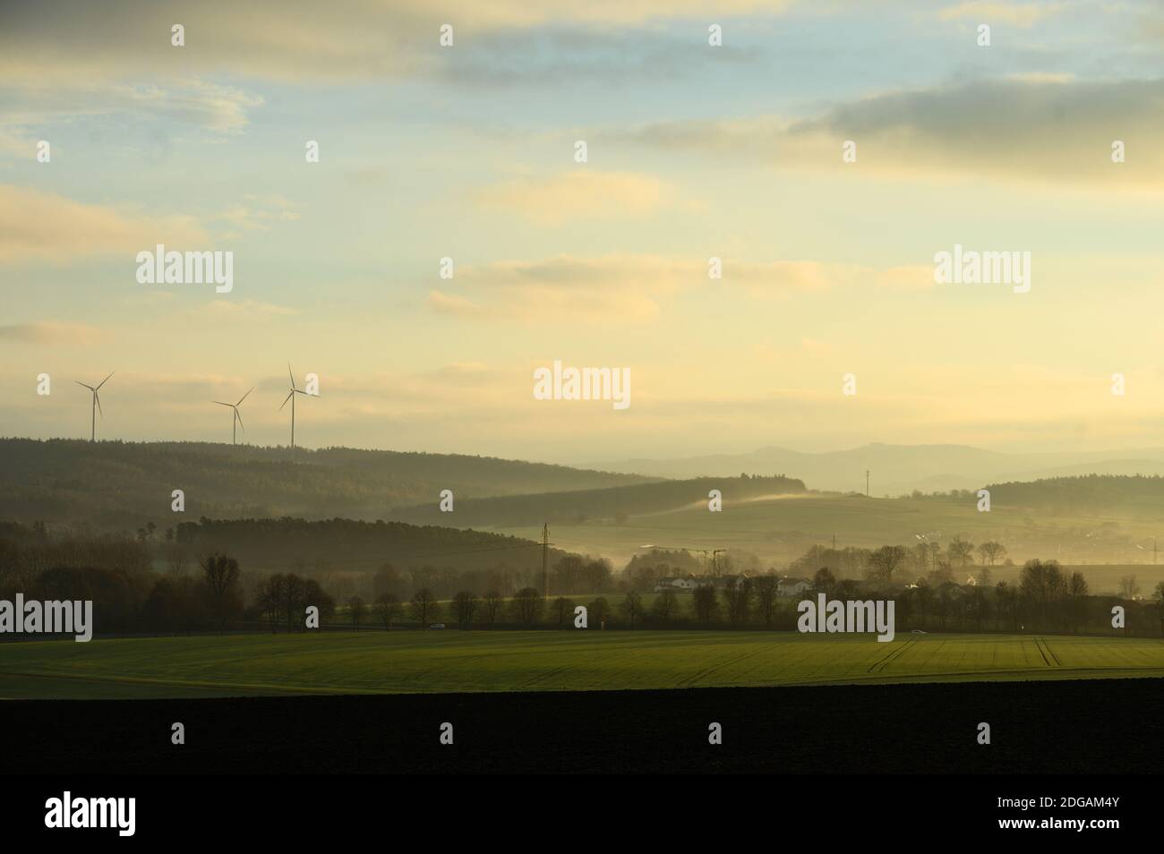 Fulda, Deutschland. Dezember 2020. Blick vom Fuldaer Stadtteil Dietershan bei Sonnenaufgang auf die Höhen des Naturparks Hessische Rhön mit Windmühlen (l). Quelle: Andreas Arnold/dpa/Alamy Live News Stockfoto