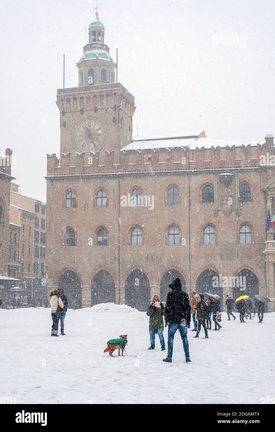 Die Leute genießen den Schnee fallen auf der Piazza Maggiore, Bologna, Emilia Romagna, Italien Stockfoto