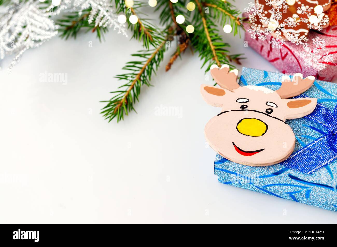 Bringen Sie Elchelche auf einer blauen Geschenkbox zum Spielzeug. Animation für eine glückliche Neujahrskarte. Weihnachtskarte. Hintergrund für den Text. Stockfoto