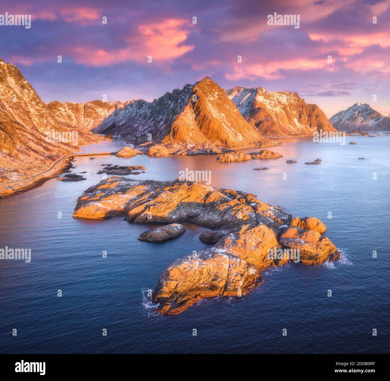 Luftaufnahme von Felsen im Meer, Berge, Himmel bei Sonnenuntergang Stockfoto