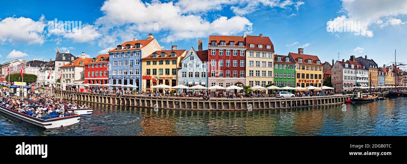Touristen in einem Tourboot mit Gebäuden entlang eines Kanals, Nyhavn, Kopenhagen, Dänemark Stockfoto