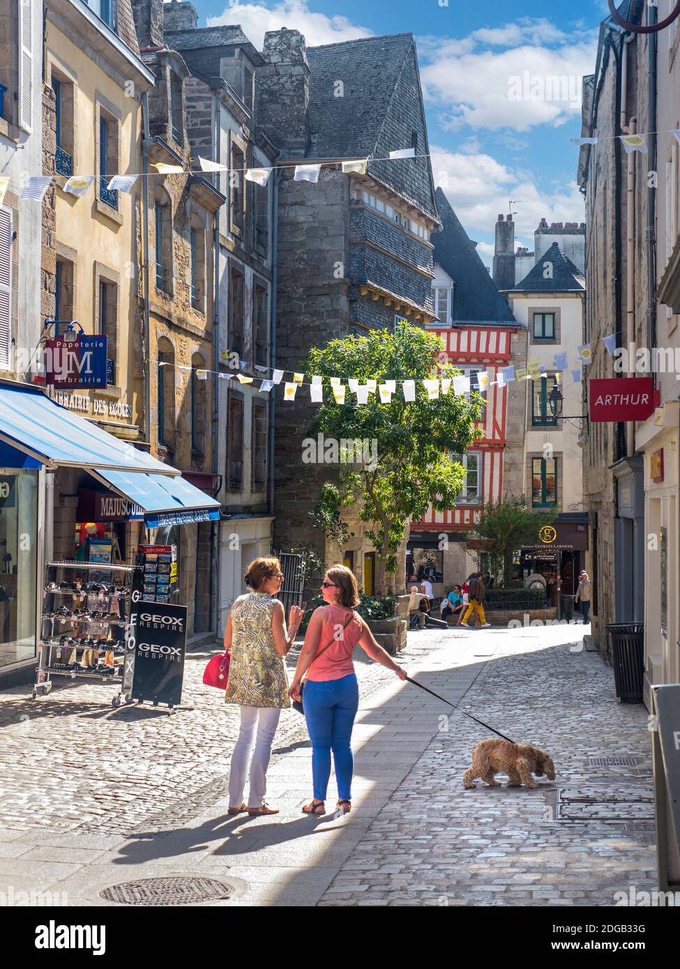 Quimper BRITTANY Lifestyle Einheimische Hund zu Fuß reden Altstadt Mittelalterliche Fußgängerzone Einkaufszentrum mit Sommer Sonne Shopper Touristen Besucher Quimper Bretagne Finistère Frankreich Stockfoto