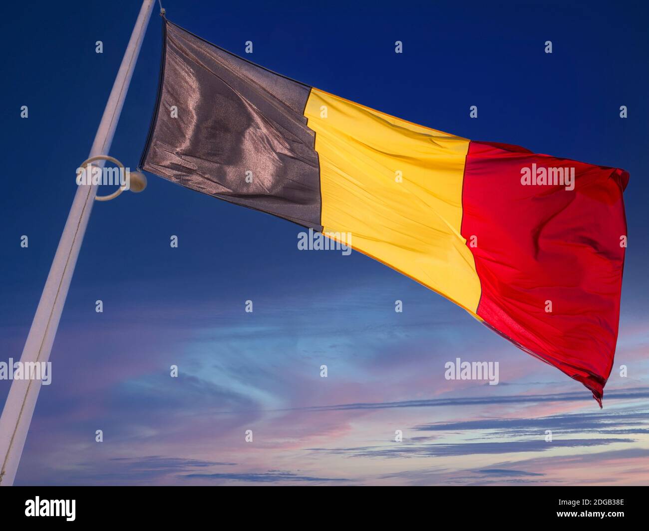 Belgische Flagge, die bei Sonnenuntergang fliegt, Belgische Nationalflagge Schwarz-Gelb-Rot, inspiriert von der französischen Trikolore, wurde 1831, kurz nach der Unabhängigkeit von den Niederlanden, übernommen. Stockfoto