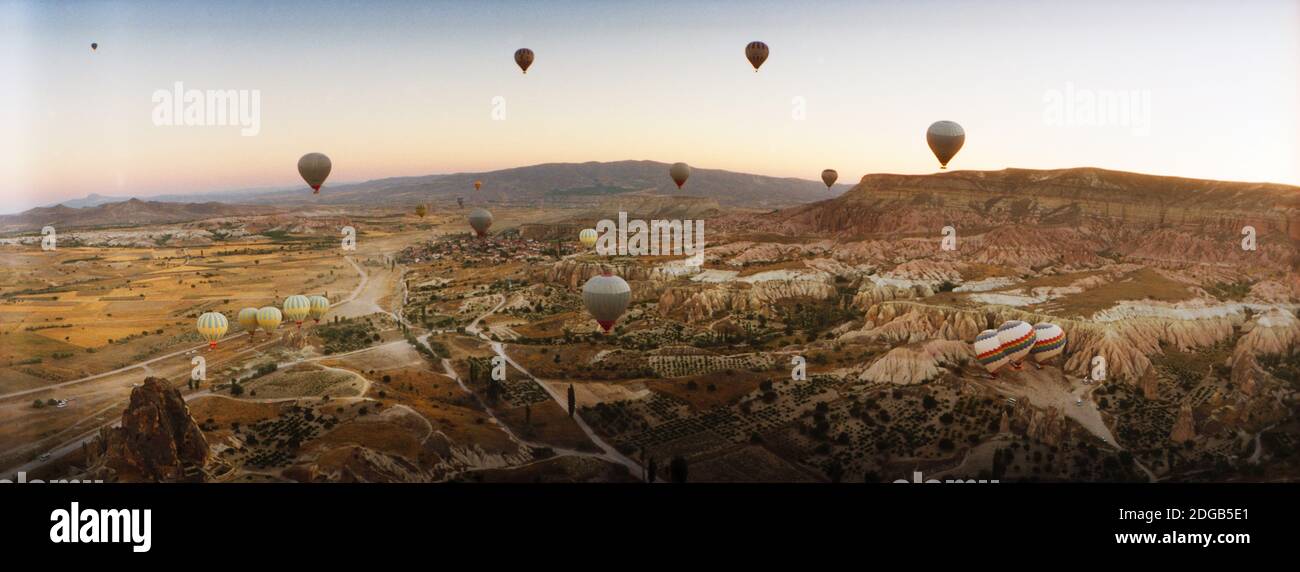 Heißluftballons über Landschaft bei Sonnenaufgang, Kappadokien, Zentralanatolien Region, Türkei Stockfoto